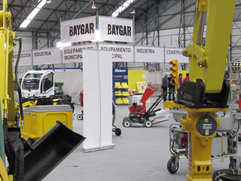 Stand de Baygar en una feria, con los rótulos Baygar, Construcción, Industria y Equipamiento municipal sobre la maquinaria expuesta
