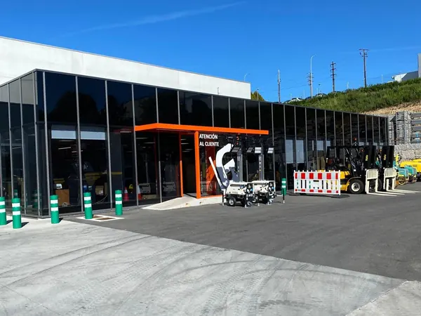 Fachada acristalada de las instalaciones de Baygar en Vigo, con la entrada de atención al cliente y maquinaria delante