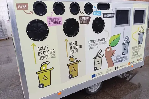 Lateral de un remolque punto limpio móvil con las bocas para pilas, aerosoles y aceite