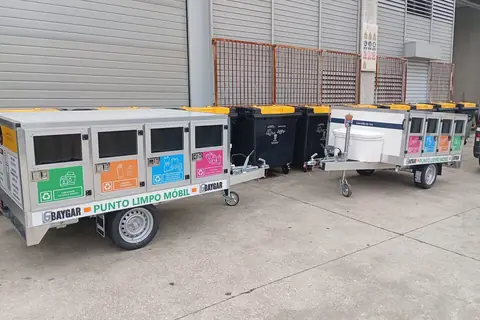 Dos remolques punto limpio móvil aparcados ante una nave