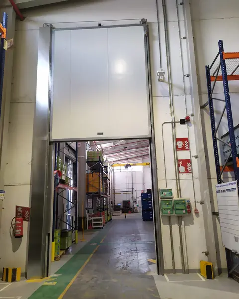 Tall sliding fire door over a passageway in an industrial building