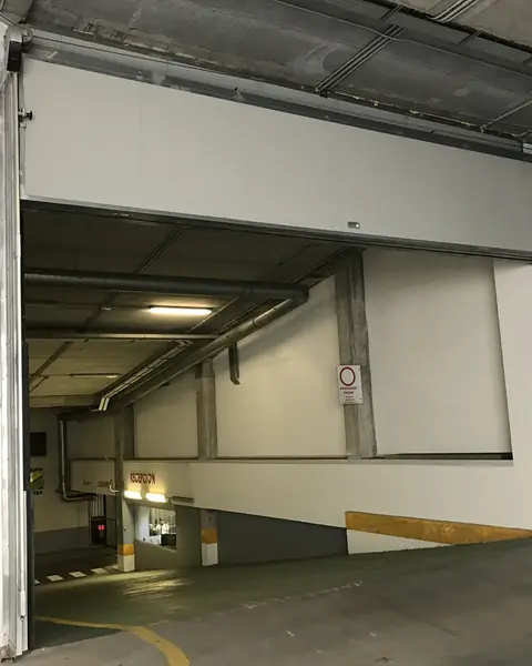 Vertical-lift fire door, open above the ramp of a covered car park