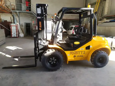 Carretilla elevadora todoterreno amarilla dentro de una nave